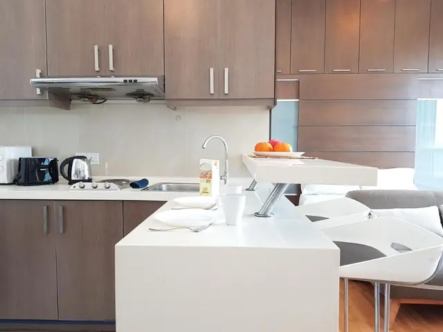 The private kitchen of a studio at KLCC Parkview 1, with a white counter, kettle and fridge