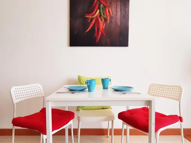 Dining table of a studio at KLCC Parkview 1, with red chairs and mugs